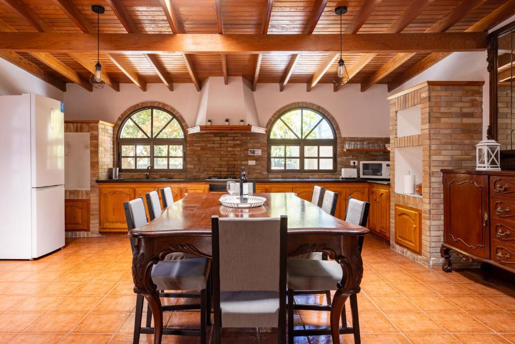 Una cocina con una gran mesa y sillas de madera. en Tegueste Charming House, en Tegueste