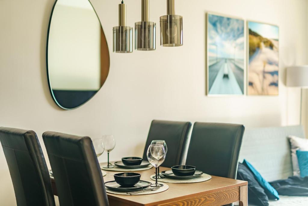 a dining room table with chairs and a mirror at CHILLIapartamenty - Wyspa Solna - RIVER in Kołobrzeg
