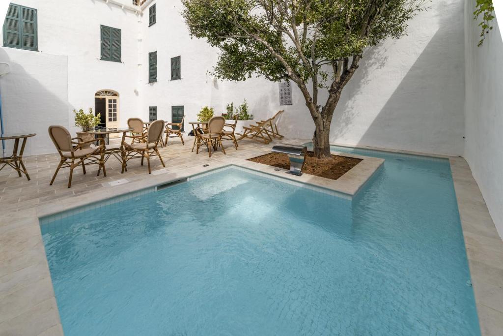 una piscina en un patio con mesa y sillas en Seranova Luxury Hotel - Adults Only en Ciutadella