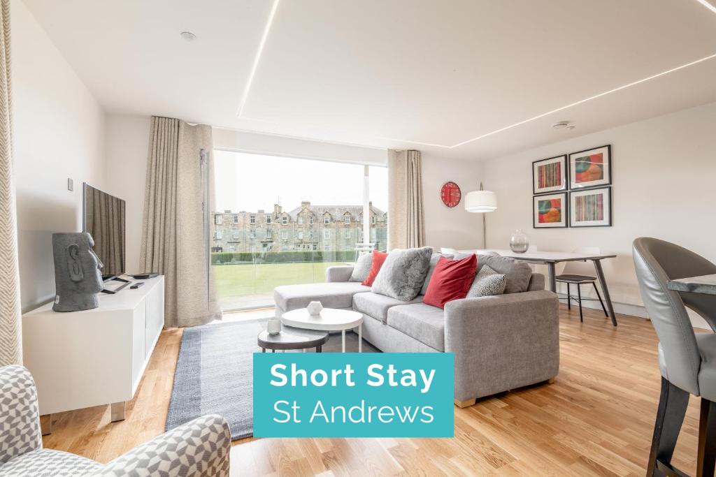 a living room with a couch and a dining room at Luxury Apartment with Balcony, Free Parking in St Andrews