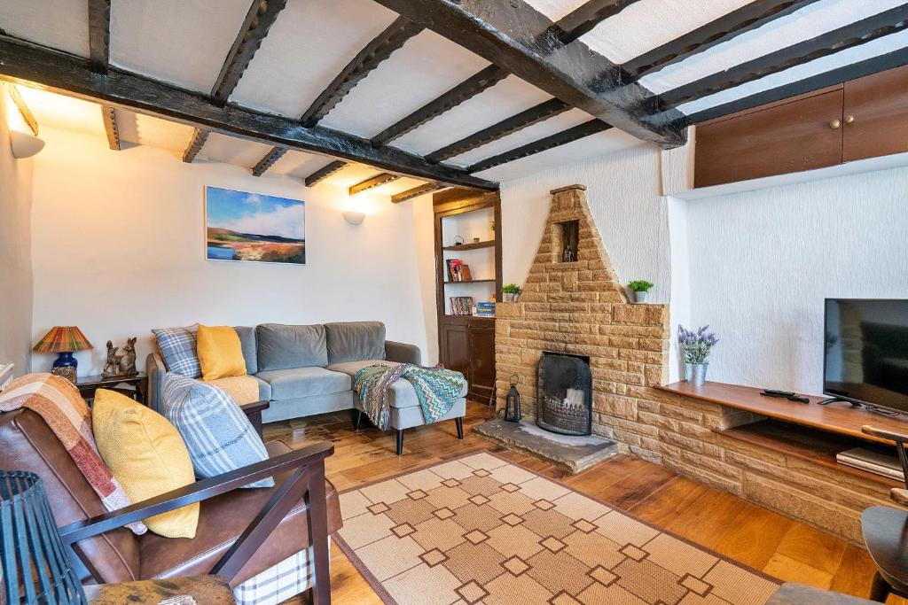 a living room with a couch and a fireplace at Finest Retreats - Westcote Cottage in Bradwell