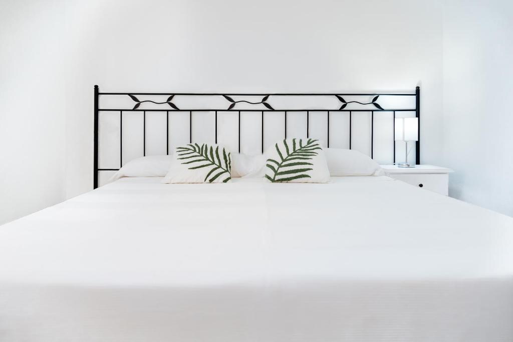 a white bedroom with a large bed with white pillows at Apartamento Antonio - Puerto Pollensa in Port de Pollensa