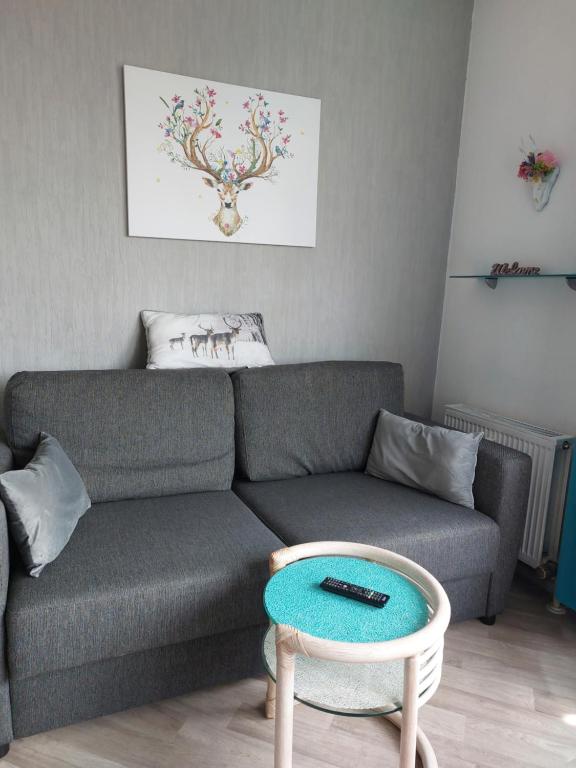 a living room with a couch and a table at Haus Sachsensteinblick Ferienwohnung Sonnenschein in Bad Sachsa