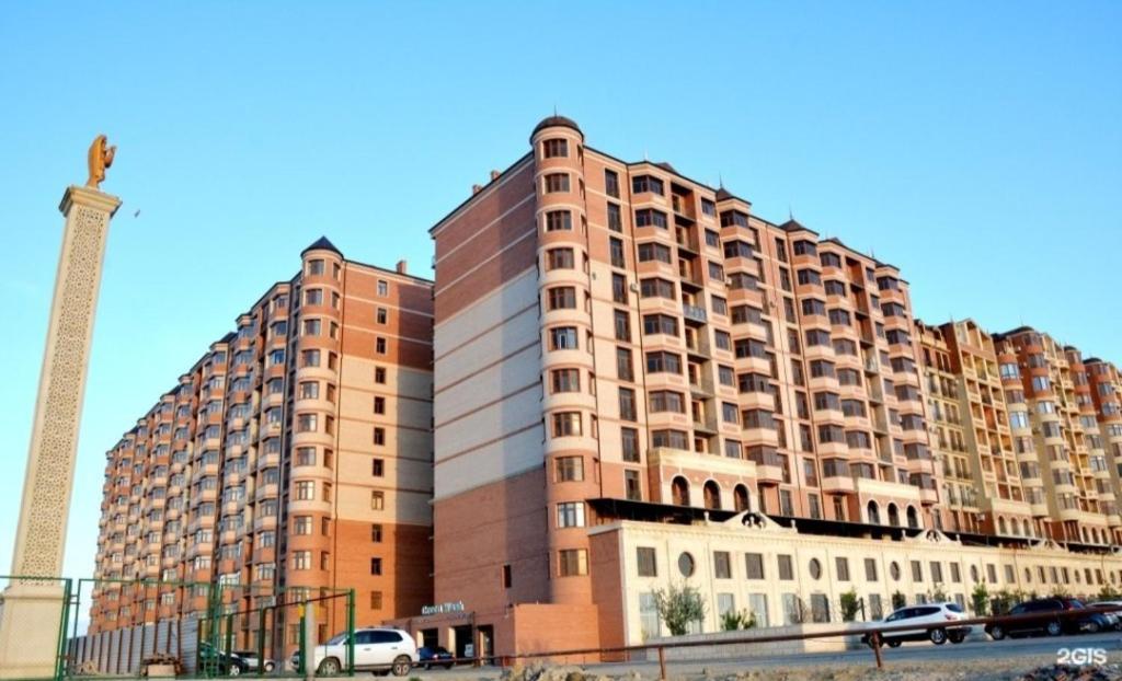 un gran edificio con una torre alta delante de él en 1 bedroom Seaside apartments in Green Park 1 комнатная квартира en Aktau