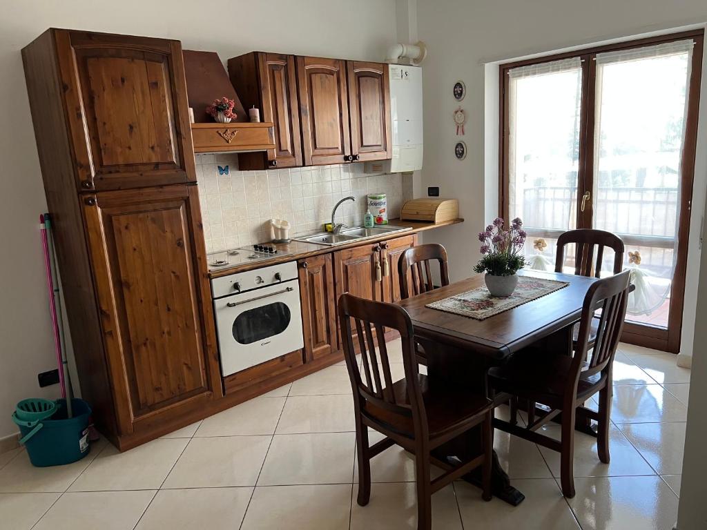 y cocina con mesa, sillas y fogones. en Il Girasole - Apartment, en Avezzano