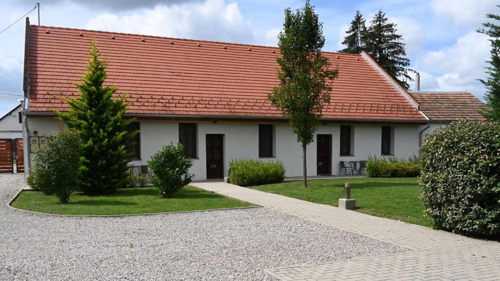 a white house with a red roof at Erdődy Vendégház in Kastélyosdombó