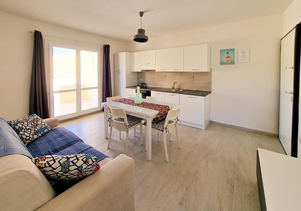 een woonkamer met een bank en een tafel met stoelen bij Murphy Holiday Homes - Residenza Solari in La Maddalena