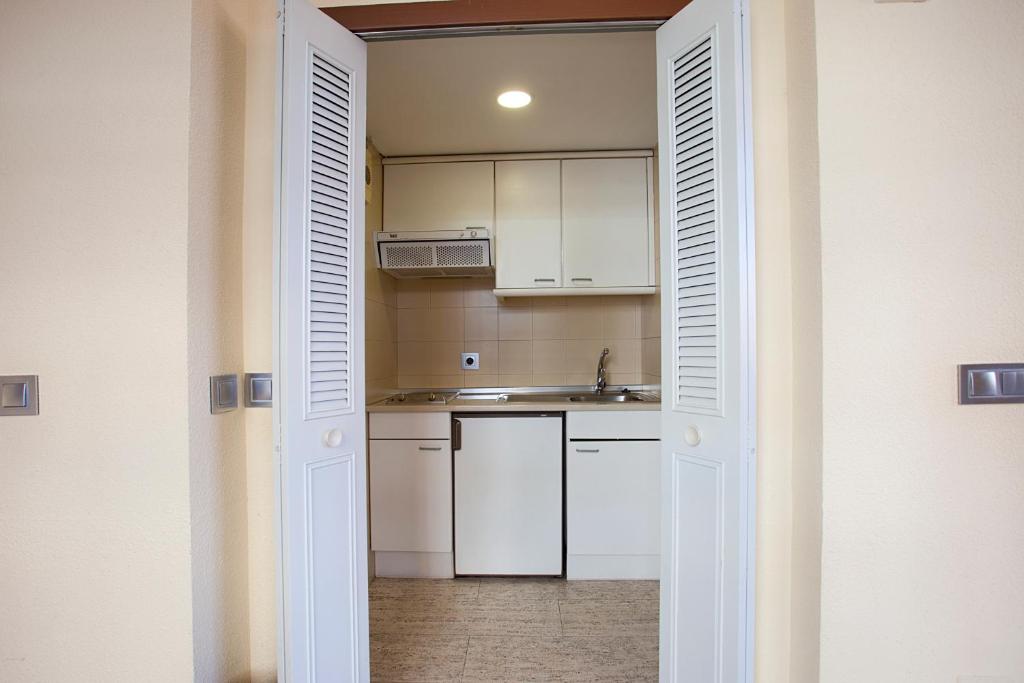 a kitchen with white cabinets and a sink at Espahotel Plaza Basílica in Madrid