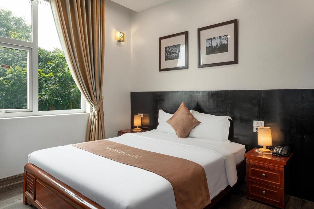 a bedroom with a large bed and a window at Truong An NoiBai Airport Hotel in Noi Bai