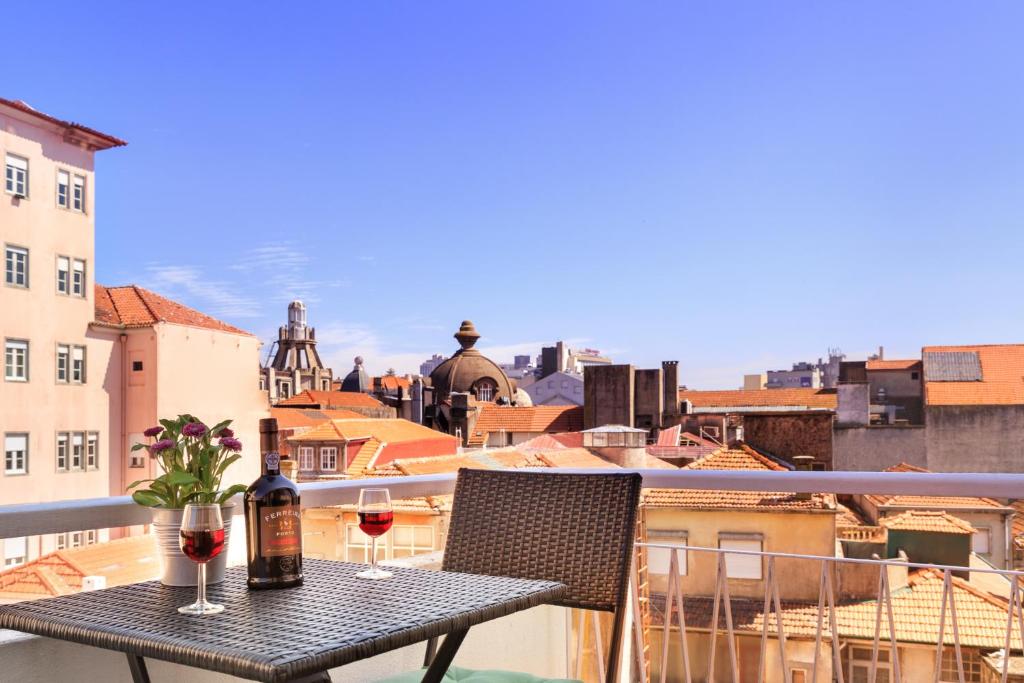 una mesa con 2 copas de vino en el balcón en Fabrica Apart en Oporto