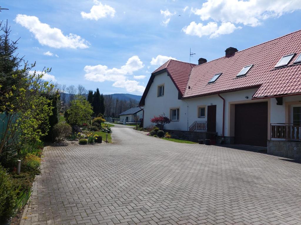 een oprit naar een huis met een rood dak bij Ubytování u Solárky in Trojanovice