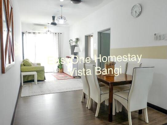 a dining room with a wooden table and white chairs at EZI homestay Vista Bangi in Kajang