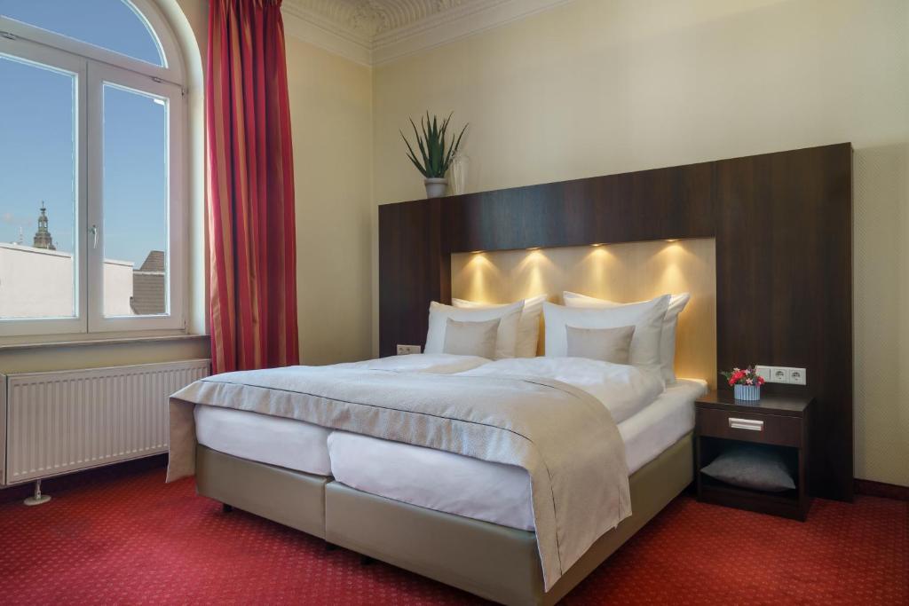a bedroom with a large bed with a large window at Novum Hotel Graf Moltke Hamburg in Hamburg