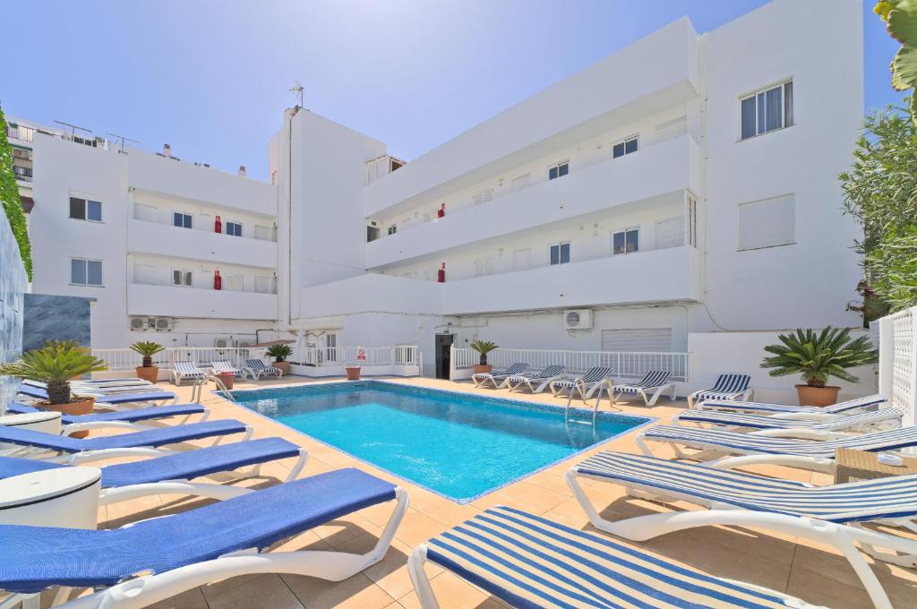 hotel z basenem i leżakami w obiekcie All Suite Ibiza Aparthotel w mieście San Antonio