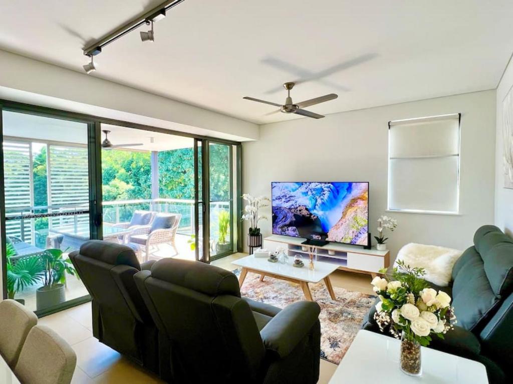 - un salon avec un canapé et une télévision dans l'établissement Waterfront Escape 2Bdr, Wavepool, Restaurants, à Darwin