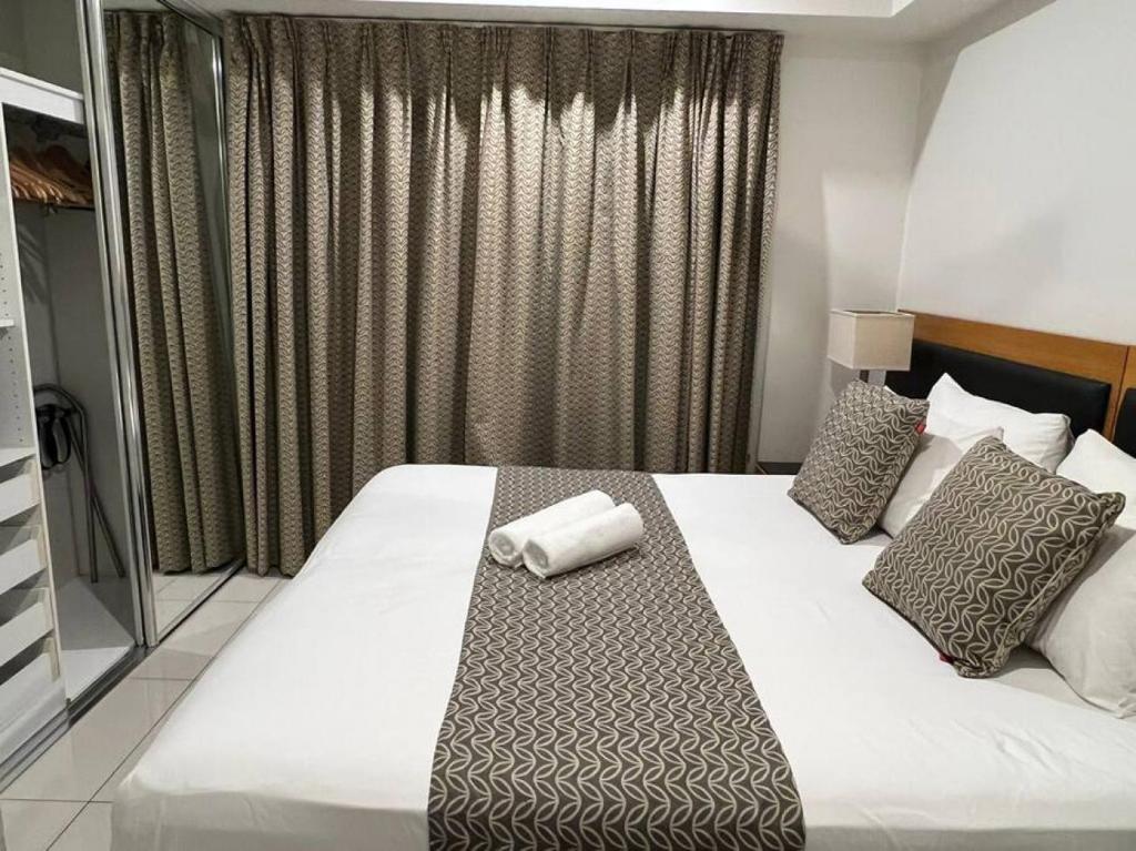una camera d'albergo con un letto e un asciugamano sopra di Sky high with harbour views a Darwin