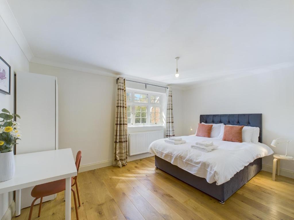a bedroom with a bed and a desk and a window at Duplex Redhill town centre Apt by Livingo Stays in Redhill