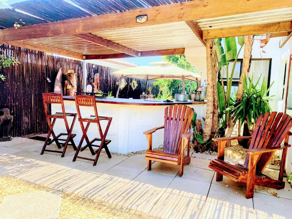 a patio with three chairs and an outdoor bar at Regent Casa's - Cape Towns Blouberg Area - Where 20 people can stay in Cape Town
