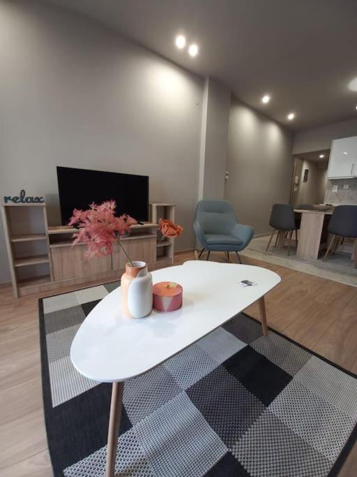 a living room with a white table in a room at Kassandrou Deluxe Apartment in Thessaloniki