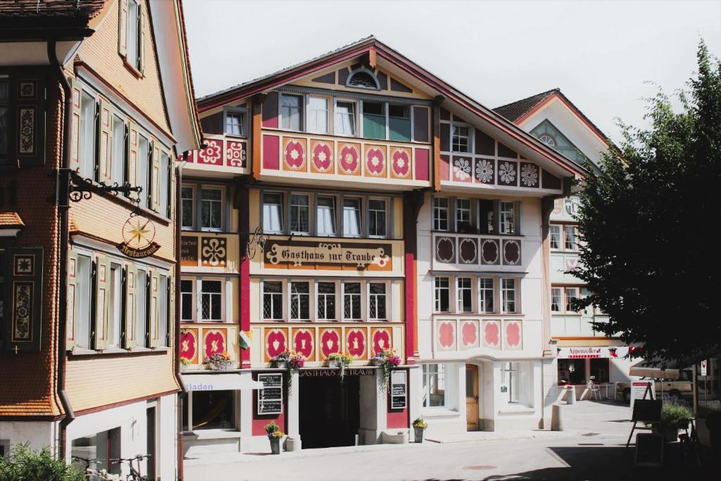a building with a pink and white building at Traube Restaurant & Hotel in Appenzell