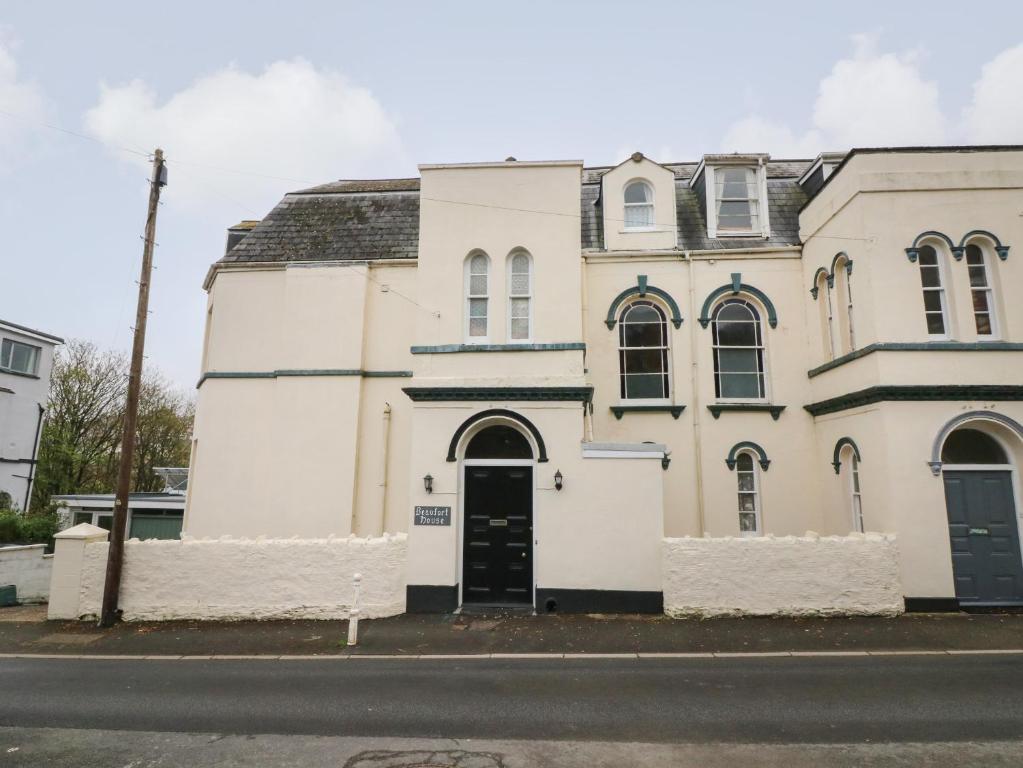 un vieux bâtiment blanc sur le côté d'une rue dans l'établissement Beaufort House, à Ilfracombe