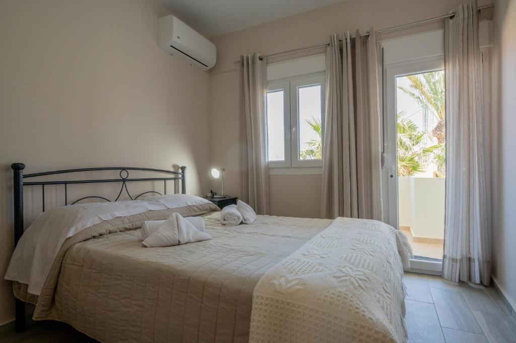 een slaapkamer met een bed en een groot raam bij Casa di Kasta, in Hersonissos in Agrianá