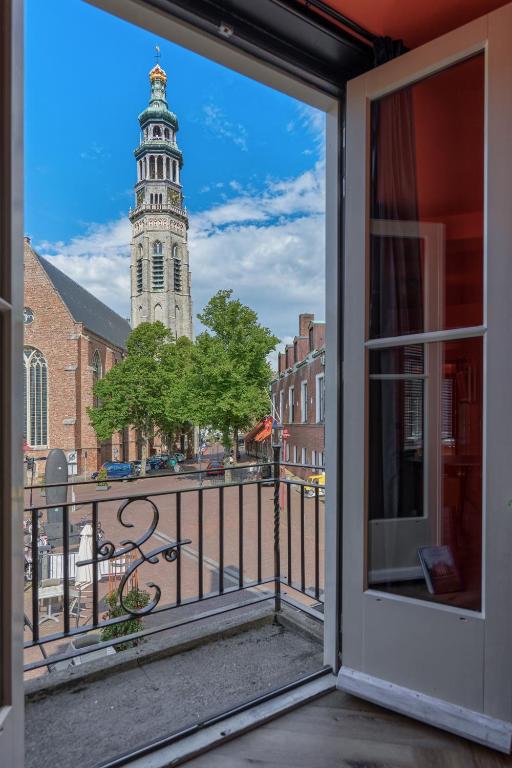 a view of a clock tower from a balcony at The Roosevelt Apartments in Middelburg