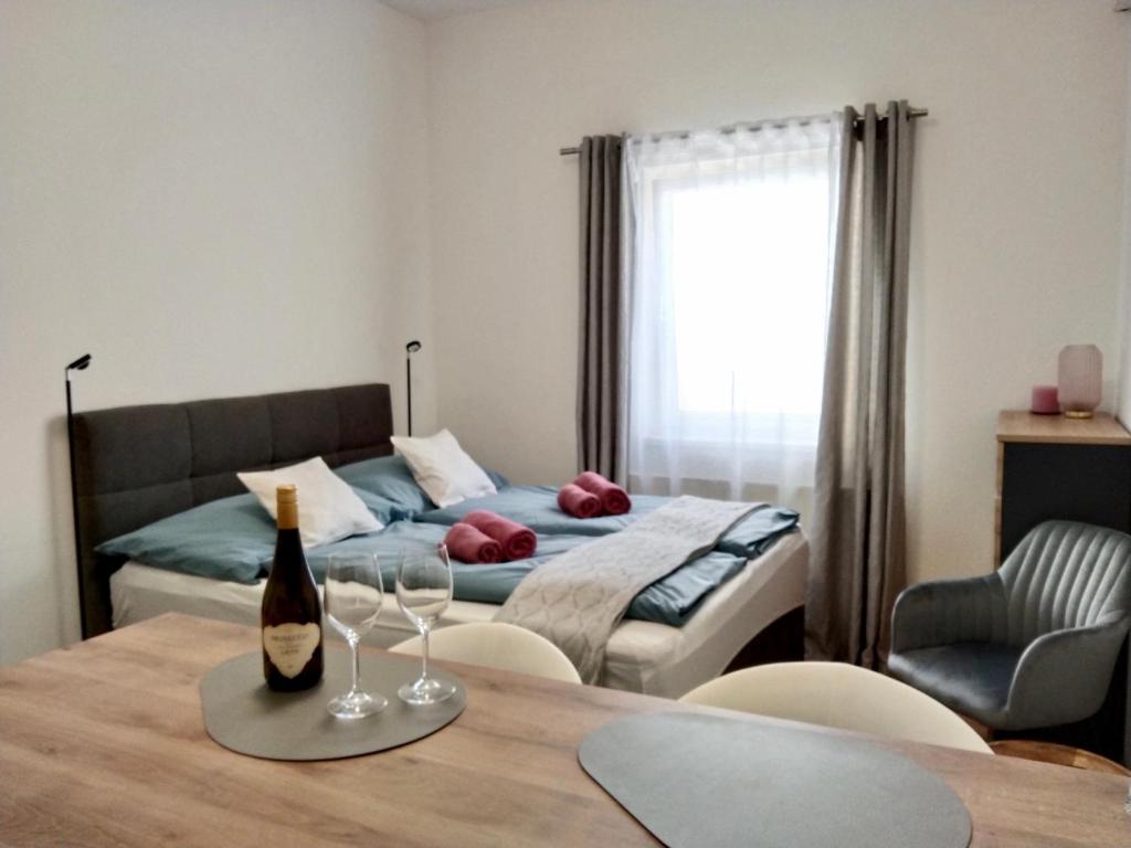 Ruhiges Ferienapartment mitten im Zentrum Sankt Pölten في سانت بولتن: غرفة نوم مع سرير وطاولة مع كؤوس للنبيذ