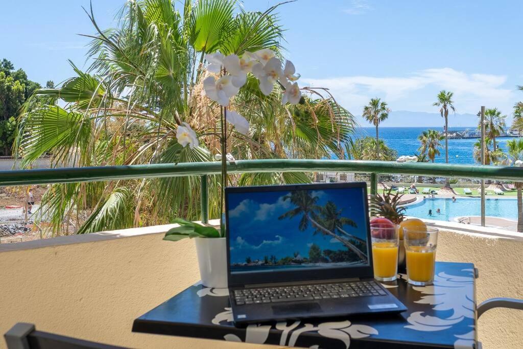 a laptop computer sitting on a table on a balcony at Apartment in front of the ocean in Los Cristianos