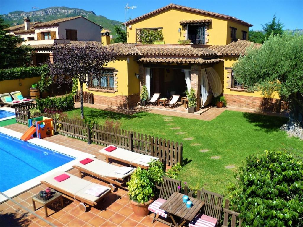 een villa met een zwembad en een huis bij Preciosa villa cerca playa Gran jardín piscina privada vallada y barbacoa Wifi in Tarragona