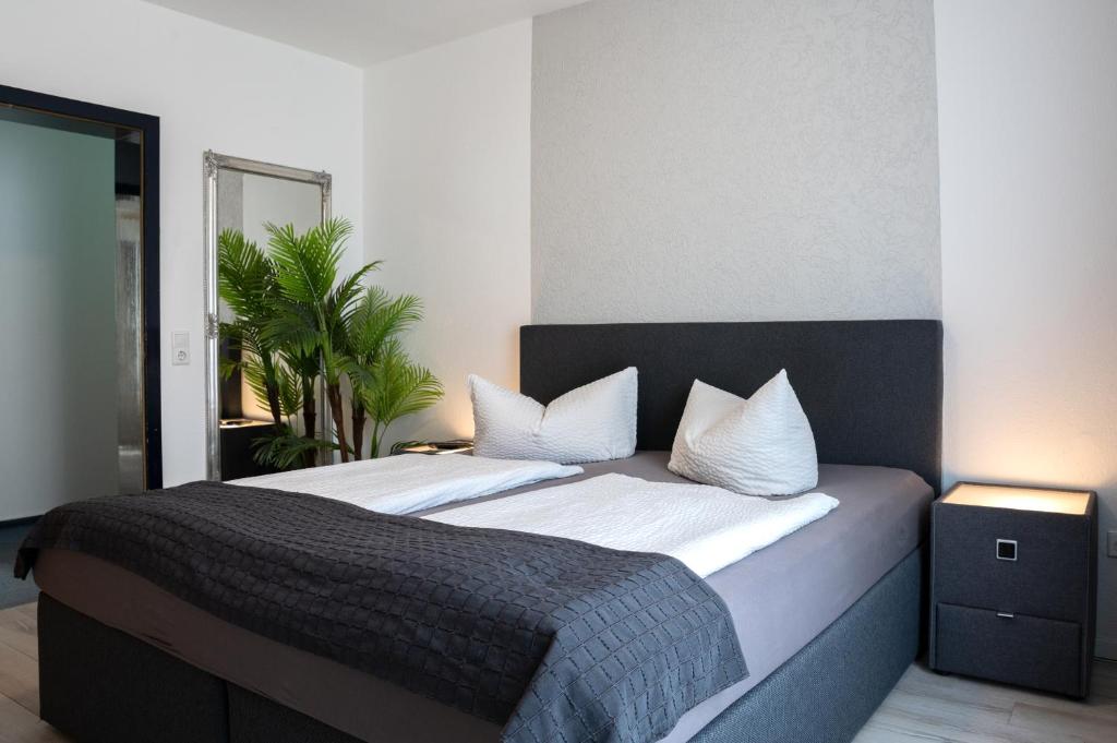 a bedroom with a large bed with white sheets and pillows at Hotel Ammerland garni in Wilhelmshaven