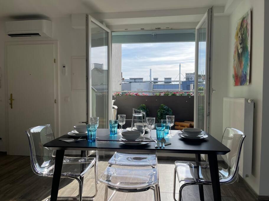 a dining room table with chairs and a table with glasses at Dachgeschoss für 4 mit Terrasse in Vienna