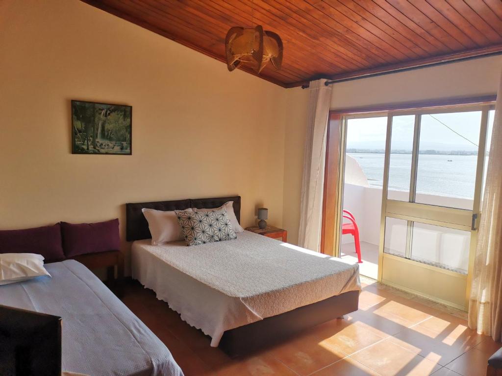 um quarto com uma cama e vista para o oceano em ''O Veleiro'' Rest. Resid. em Torreira