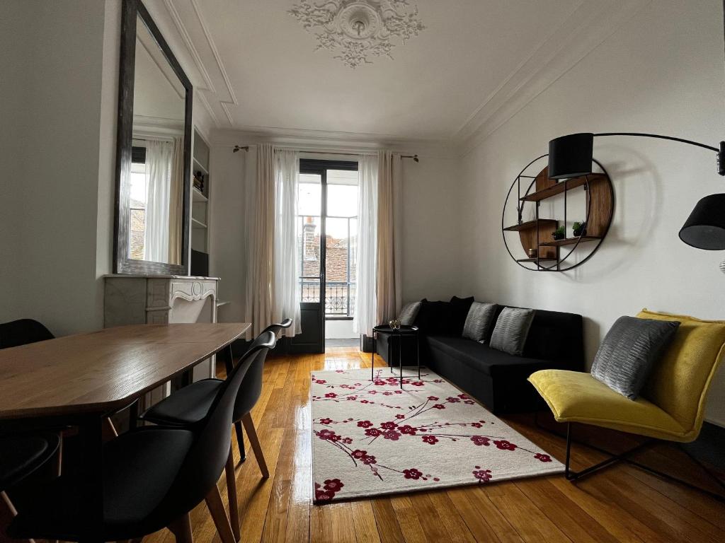 - un salon avec une table et un canapé dans l'établissement superbe appartement belifontain coeur de ville, à Fontainebleau