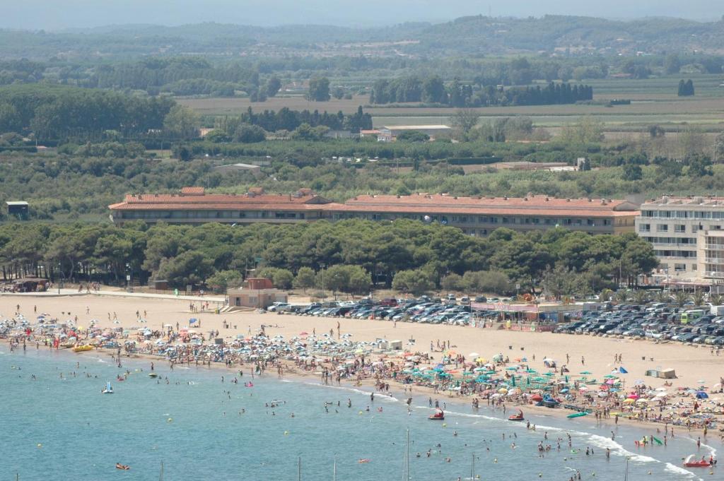 a group of people on a beach with umbrellas at La Pineda I 1 3-6 in L'Estartit