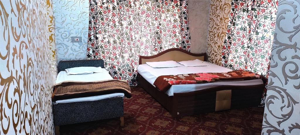 a small bedroom with two beds and curtains at Hotel Fabulous Kashmir in Srinagar