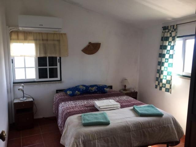a bedroom with a bed with two green towels on it at AL Miradouro do Outeiro in Guarda