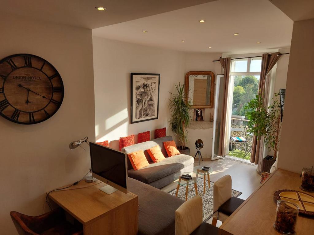un salon avec un canapé et une horloge au mur dans l'établissement Stanislas sea view, à Cannes