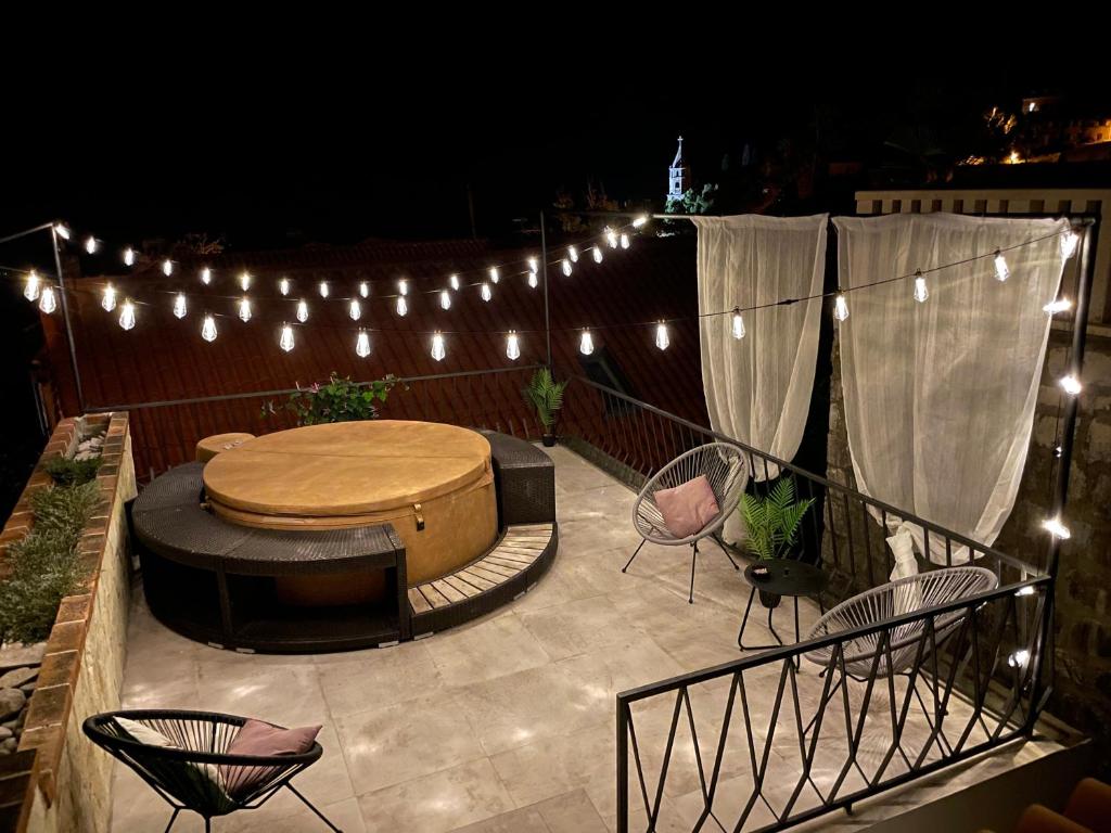 un patio con tavolo, sedie e luci di Villa Lizza a Cavtat