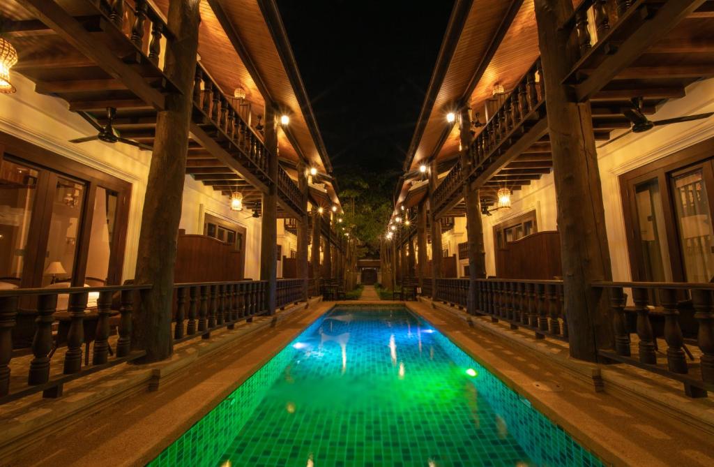 a swimming pool in an old building at night at Treasure Hotel Laos in Luang Prabang