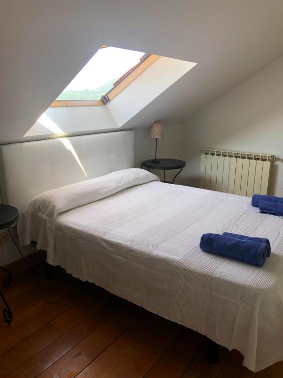 Schlafzimmer mit einem großen Bett und einem Dachfenster in der Unterkunft Dúplex con vistas a la ría de Mogro by Alterhome in Mogro