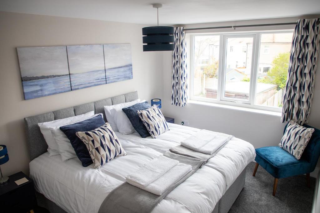 um quarto com uma cama grande e uma cadeira azul em Wave Stays - First Floor Apartment em Cleveleys