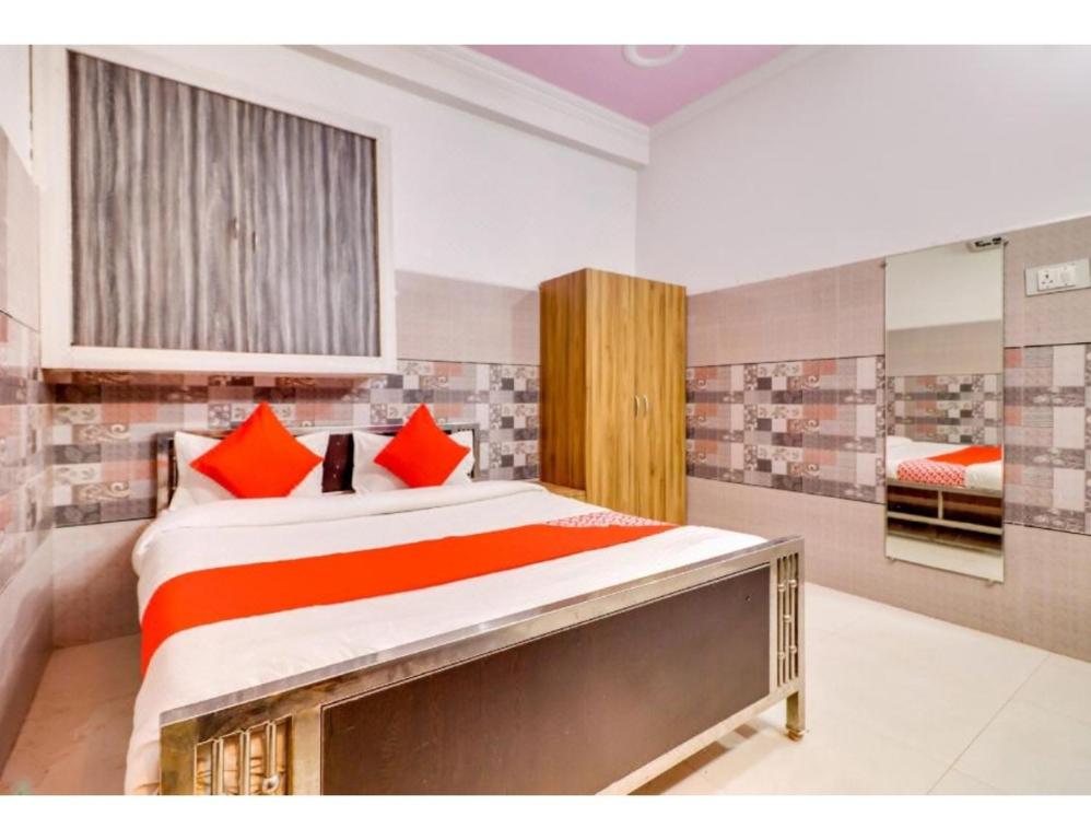 アラハバードにあるHotel Shree Urmila, Prayagrajのベッドルーム1室(大型ベッド1台、赤い枕付)