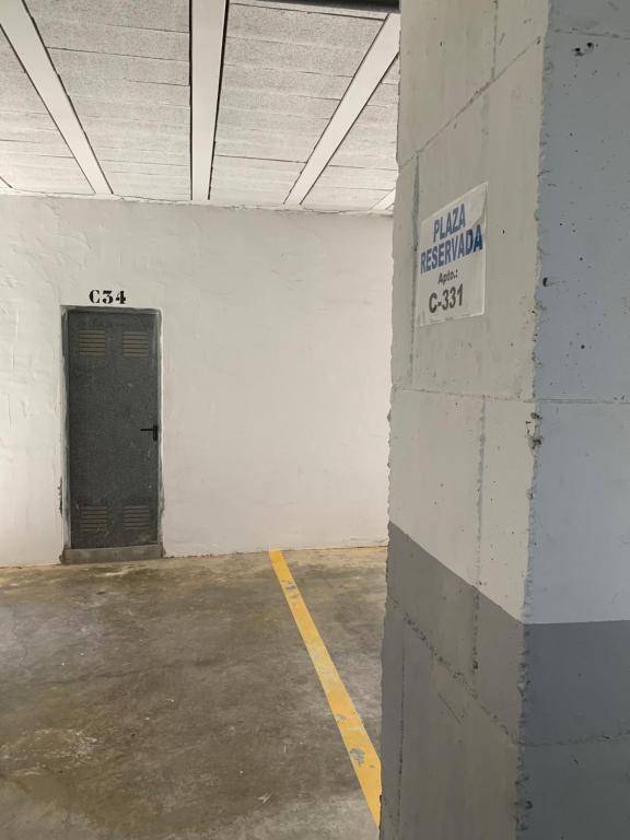 a parking garage with a black door and a sign on a wall at Apartamento Zahara in Zahara de los Atunes