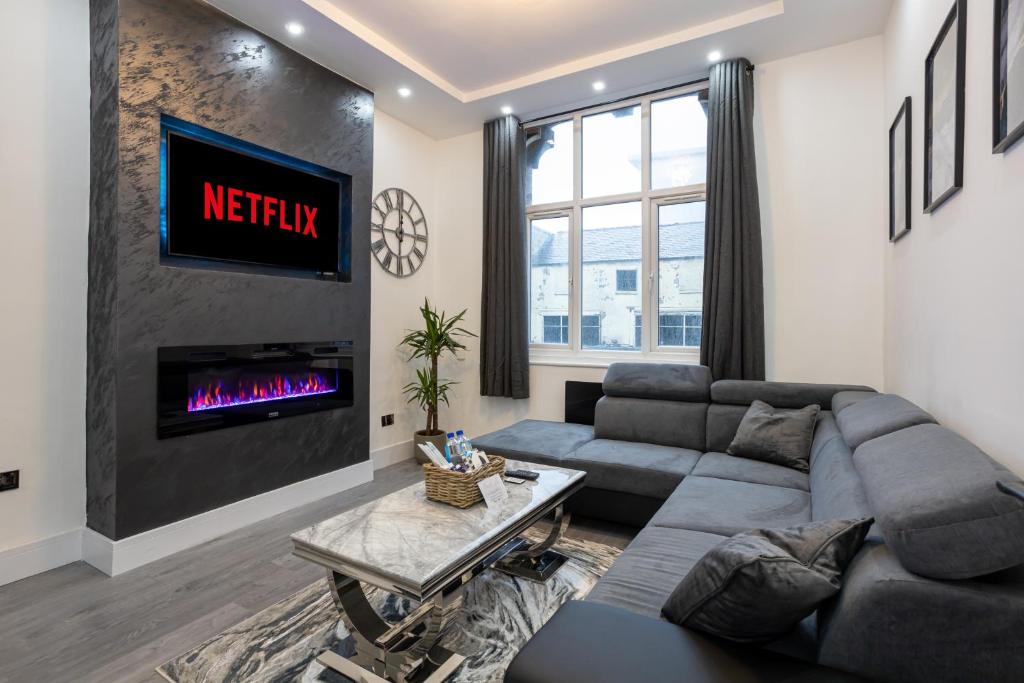 a living room with a couch and a fireplace at Luxurious Duplex in Bolton – Sleeps 6 – Parking in Bolton