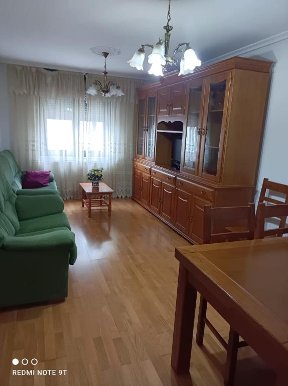 - un salon avec un canapé vert et une table dans l'établissement apartamento de dos habitaciones en Quiroga, à Quiroga