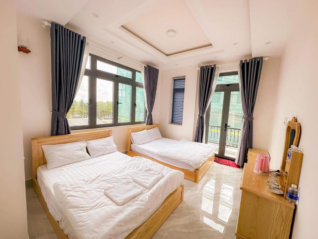 2 Betten in einem Zimmer mit Fenstern in der Unterkunft 1994 House in Da Thanh