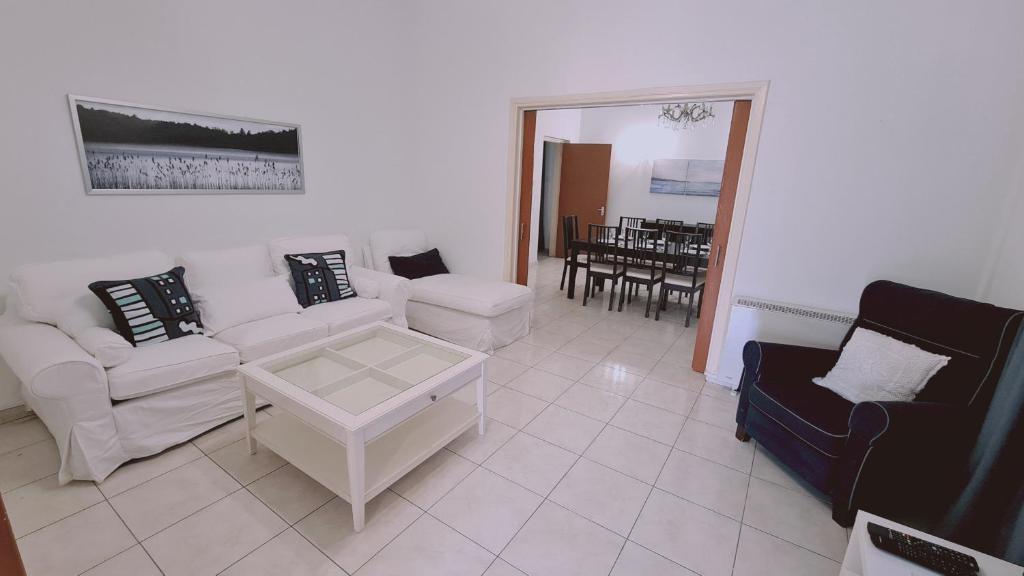 a living room with white furniture and a dining room at STAY Mythos Down Town House in Nicosia