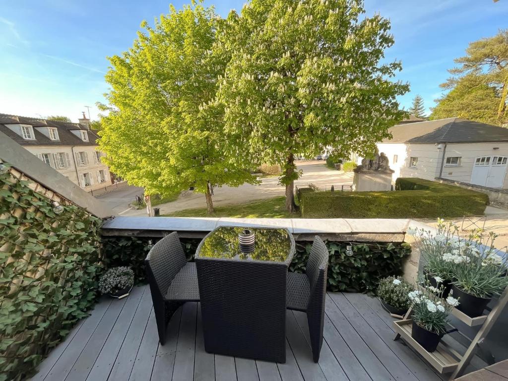 a patio with a table and chairs on a deck at Villa Napoléon in Pierrefonds