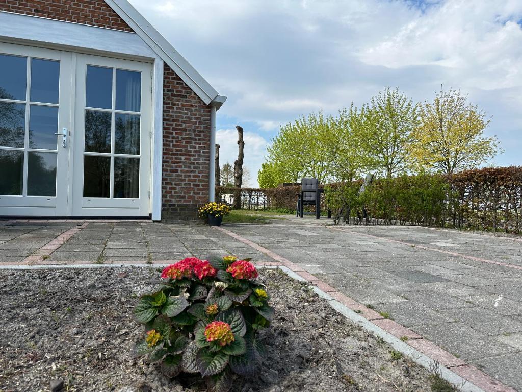 ein Haus mit einer Tür mit Blumen davor in der Unterkunft byTilch in Borgercompagnie
